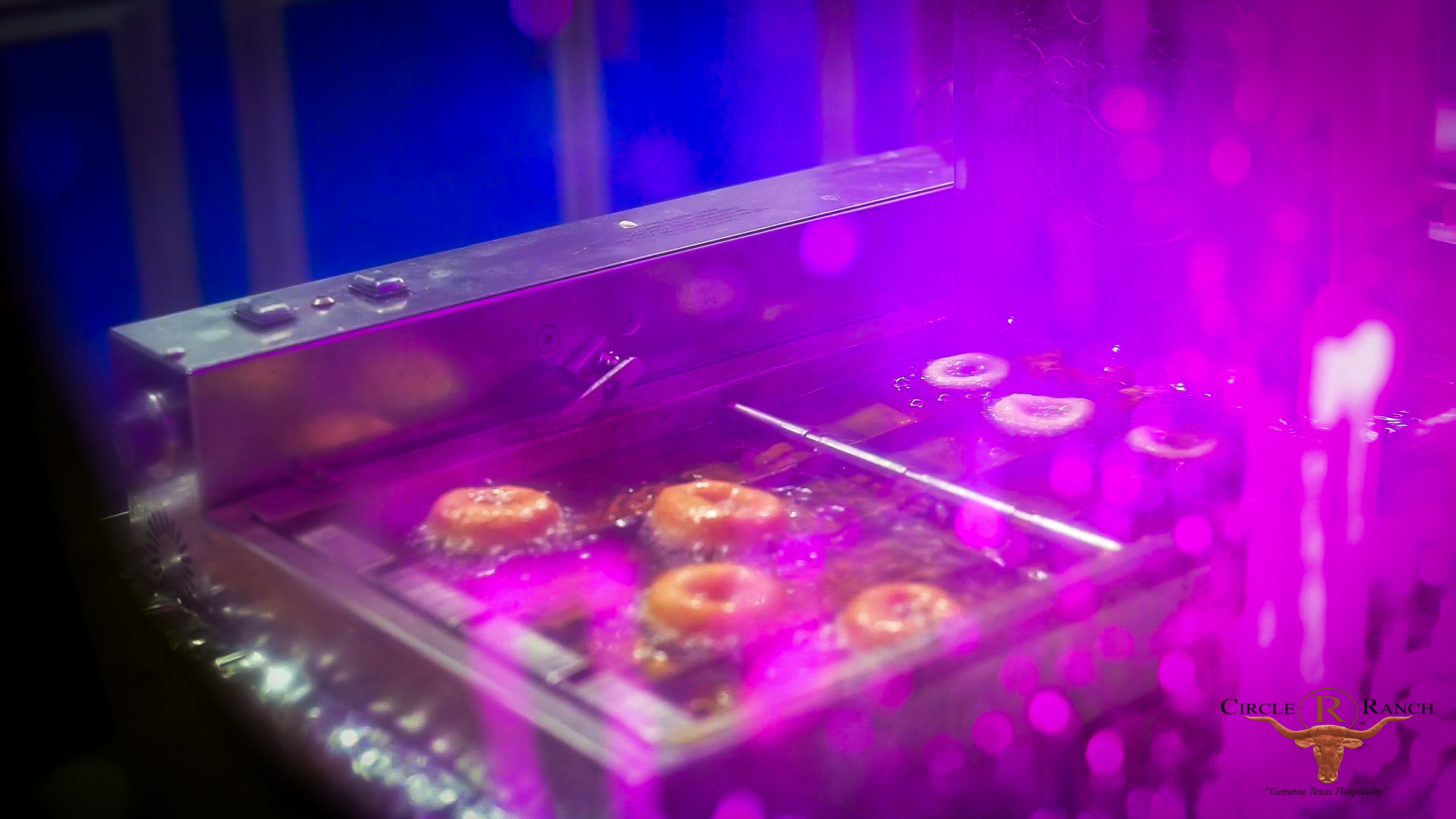 Mini donuts frying under purple event lights