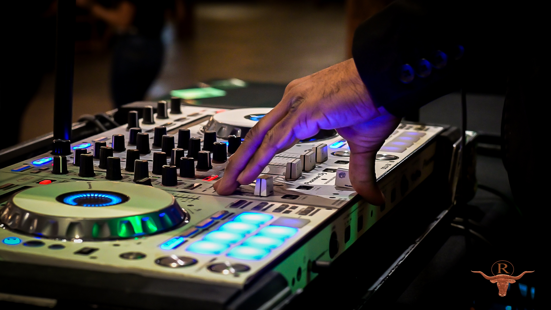 Pioneer DJ mixer lit up in blue and green